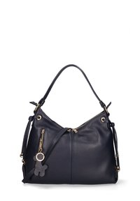 Navyblauwe leren handtas met een slouchy ontwerp, gouden hardware accenten, een bovenrits en een kleine sleutelhanger in de vorm van een beer bevestigd.