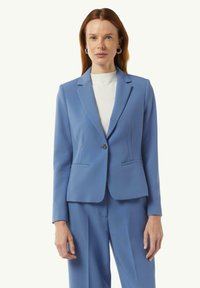 Lichtblauwe op maat gemaakte blazer met een enkele knoopsluiting, notch revers en twee voorkeurszakken. Gemaakt van gladde stof, slim fit ontwerp.