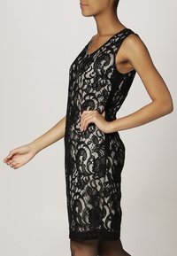 Černé krajkové šaty s fitted siluetou, bezrukávovým designem, květinovými vzory a kulatým výstřihem, s délkou po kolena.