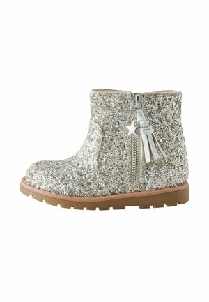 Kindlicher glitzernder silberner Knöchelstiefel mit seitlichem Reißverschluss und Stern- sowie Quastenanhänger, braune Gummisohle.