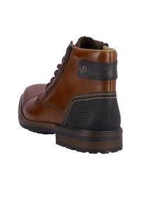 Bottines en cuir brun avec un panneau noir texturé, lacets sur le devant, fermeture éclair sur le côté et semelle robuste pour une meilleure adhérence.