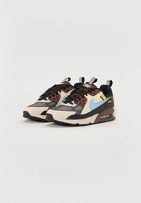 Tenisky Nike Air Max kombinujúce krémové, hnedé, čierne a modré materiály, s akcentmi z ventilovanej látky a viditeľnou vzduchovou jednotkou v pode.