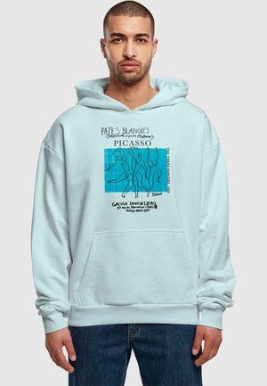 A light blue hoodie featuring a front pocket, with black text and a blue graphic design inspired by Picasso's "The Three Dancers."