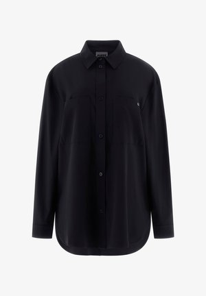 Camisa negra abotonada de tela suave, con cuello puntiagudo, dos bolsillos en el pecho y mangas largas con puños abotonados.