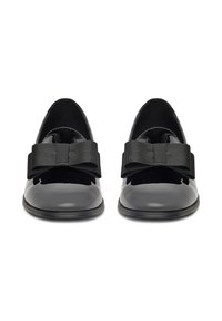 Czarne lakierowane buty z zamszowym akcentem, z dużą czarną kokardą na przodzie i niskim profilem.