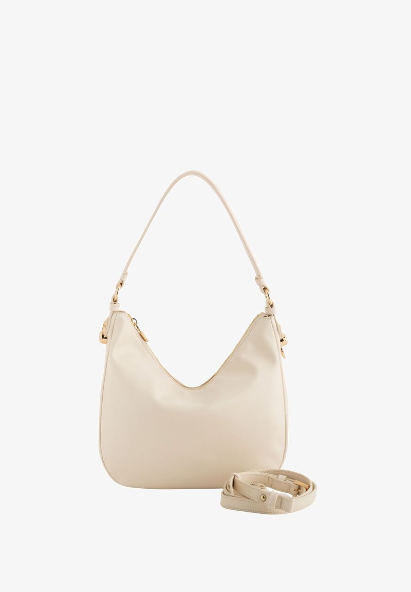 Kermapian värinen olkalaukku, joka on valmistettu sileästä nahasta, ja siinä on kaareva muoto, kultaiset metalliosat ja irrotettava yhteensopiva hihna.