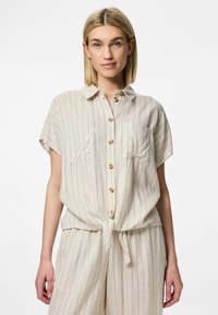 Camicia a maniche corte con colletto in beige chiaro, caratterizzata da righe verticali e chiusura con bottoni. Due tasche sul petto e dettaglio anulare sul davanti.