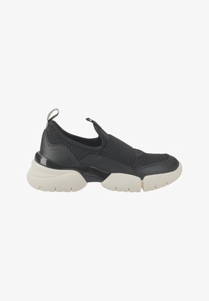 Zapatilla negra tipo slip-on con material de malla, suela contrastante color crema, suela de goma resistente y una lengüeta trasera para facilitar su colocación.