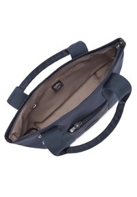 Sac bleu marine en tissu texturé, avec deux poignées courtes, fermeture éclair, et un intérieur clair équipé d'une poche zipp ée et d'une étiquette de marque.