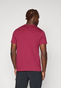 Bordeaux-farbenes T-Shirt mit kurzen Ärmeln aus weicher Baumwolle. Hat einen klassischen Rundhalsausschnitt und eine normale Passform, mit einer glatten Textur und ohne sichtbare Logos.