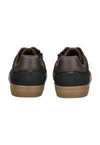 Černé semišové tenisky s tmavě hnědou koženou patou a světlou gumovou podrážkou. Mají polstrovaný límec a jemné pruhované detaily na patě.