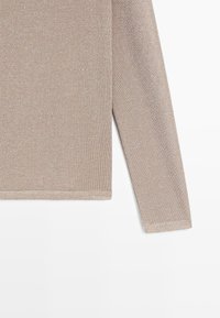 Maglione a maniche lunghe beige in maglia con dettagli in filo metallico fine e semplice cucitura sull'orlo delle maniche e del fondo.