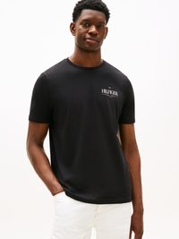 Black short-sleeved T-shirt made from soft fabric featuring a small white "HILFIGER" logo on the left chest and a round neckline.