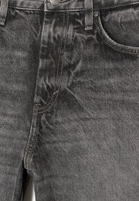 Jean en denim noir avec une finition texturée, cinq poches et des coutures contrastées, présentant un design classique avec une touche moderne.