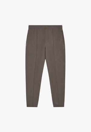 Pantaloni sportivi da uomo a gamba affusolata in un colore marrone tenue, realizzati in tessuto morbido. Presentano tasche laterali e una cintura liscia con dettagli di cucitura discreti.