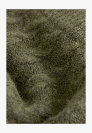 Close-up van olijfgroene gebreide stof met dikke, textuurrijke vezels, een zachte, pluizige uitstraling en zichtbare stikpatronen.