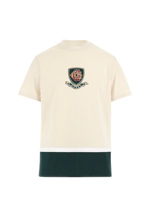 Kreemi puuvillane T-särk, millel on rinnal roheline ja punane tikand, tume roheline alumine paneel ja valge aktsenttriip.