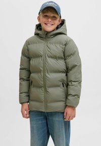 Tamsiai žalia pūkinė striukė su kapišonu, su priekiniais užtrauktukais, elastingomis rankovėmis ir dviem šoninėmis kišenėmis su užtrauktukais. Modelis - vaikas, dėvintis džinsus.