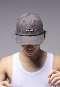 Șapcă gri cu dungi portocalii, având un patch frontal cu inscripția "FORMER." Confecționată din material textil, cu bor structurat și găuri de ventilație.
