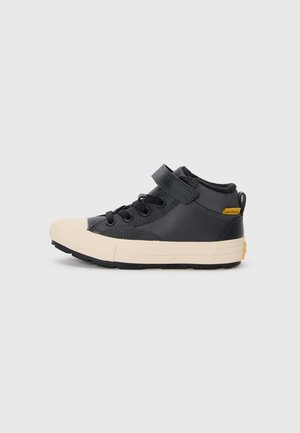 Czarne sneakersy typu high-top z teksturowanej skórzanej cholewki, kremowym gumowym noskiem, czarnymi sznurowadłami i bocznym paskiem. Posiada żółty detal z logo.