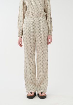 Loose-fitting pants in beige with a geometric pattern in black. Made of soft fabric with an elastic waistband and side pockets.
