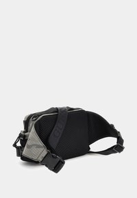 Schwarze und graue Schultertasche mit strukturiertem Netzpaneel, doppelten Reißverschlüssen und verstellbarem Riemen mit "GUESS"-Branding. Kompaktes, eckiges Design.
