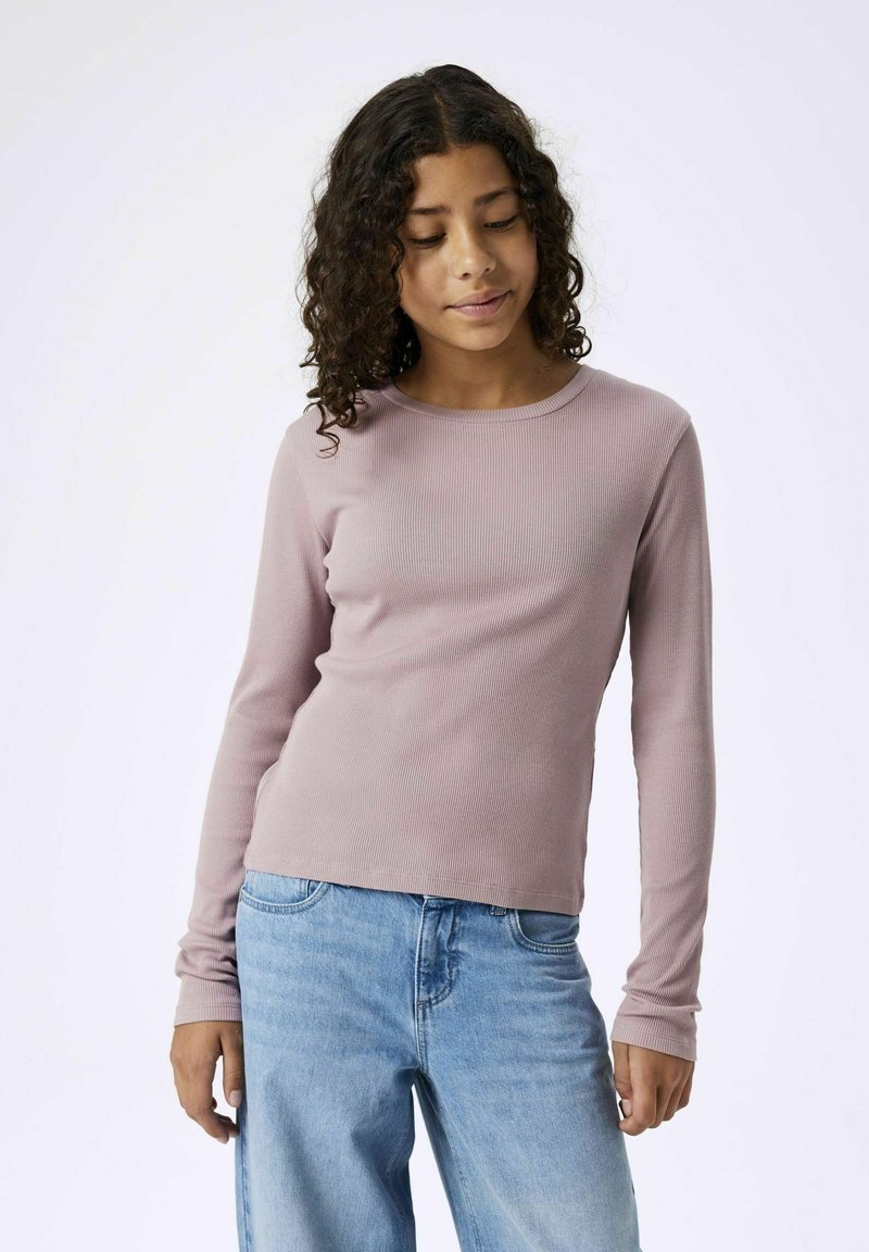 Langärmliges, geripptes Oberteil in sanftem Mauve mit rundem Halsausschnitt, kombiniert mit hellblauen Jeans; hat figurbetonte Ärmel und ein minimalistisches Design.