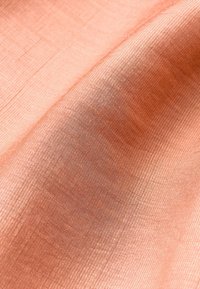 Softer, strukturierte Stoff in hellem Koralle, mit einem leichten Glanz und subtilen, feinen Linien, die parallel zur Webart verlaufen.