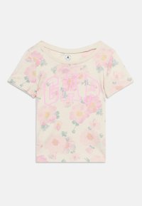 Κοντομάνικο κρεμ παιδικό μπλουζάκι με ροζ και κίτρινο ανθικό σχέδιο και μεγάλο ροζ περίγραμμα με το λογότυπο "GAP" στο μπροστινό μέρος.