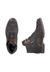 Bottes en suède gris foncé avec un panneau en tissu texturé, accents marron, œillets en métal, détail de fermeture éclair sur le côté et semelles en caoutchouc robustes.