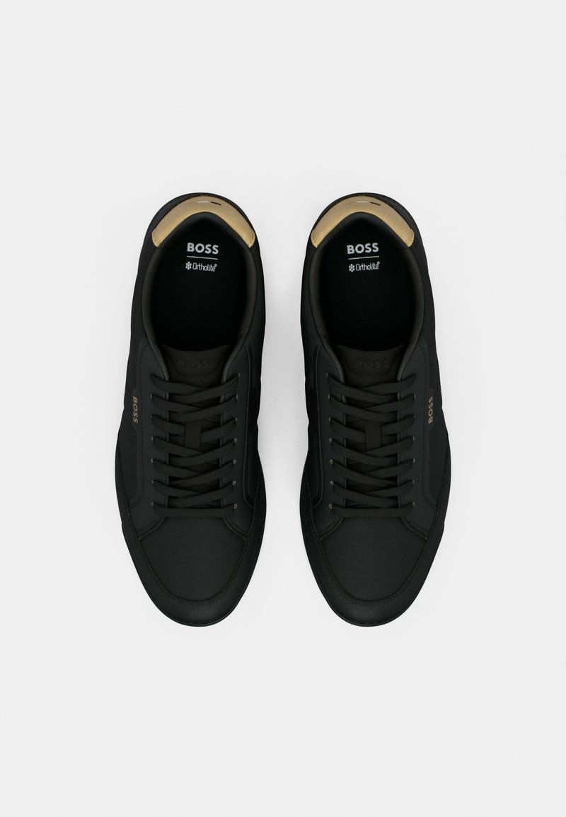 Paire de baskets basses noires de marque BOSS avec lacets et doublure intérieure beige, vue de dessus sur fond blanc.