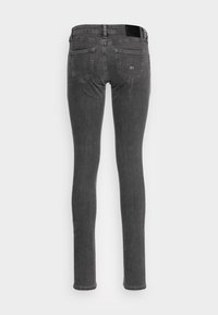 Jeans de mezclilla gris ajustados con una cintura de media altura, cinco bolsillos y un parche de cuero negro con marca en la parte trasera de la cintura.