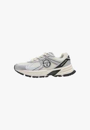 Zapatilla deportiva blanca y gris con parte superior de malla, detalles en la suela negra, cierre de cordones y la marca "Sergio Tacchini" en el lateral.