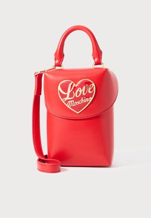 Small red leather handbag with top handle, adjustable strap, and gold heart-shaped emblem reading "Love Moschino" on front flap.