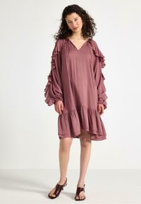 Lös passform, mauve klänning med volangärmar och ett lager på lager-ärmslut. Tillverkad av lätt viktigt material, med V-ringning och rynkade detaljer.