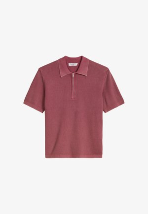 Short-sleeve ribbed polo shirt in muted mauve with a front half-zip and classic collar, knit fabric texture visible.