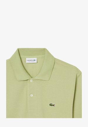 Lichtgroene Lacoste klassieke fit poloshirt met kraag, twee knopen en een groen krokodillenlogo op de borst.