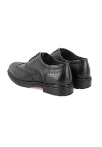 Zwarte leren schoenen met een gestructureerd oppervlak, gedetailleerd broguepatroon, ronde neus en duurzame rubberen zool. Voorzien van traditionele veters.