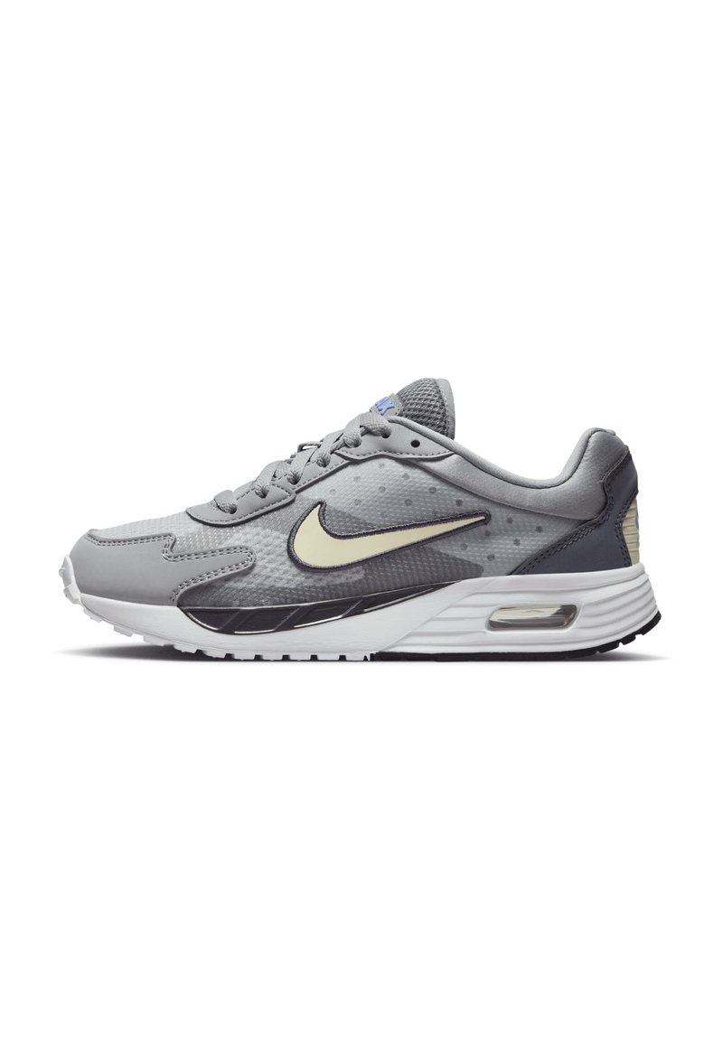 Nike Air Max sneaker szürke színben, texturált felsőrésszel, fehér középtalppal, visszafogott fekete részletekkel, és látható légpárnázással a saroknál.