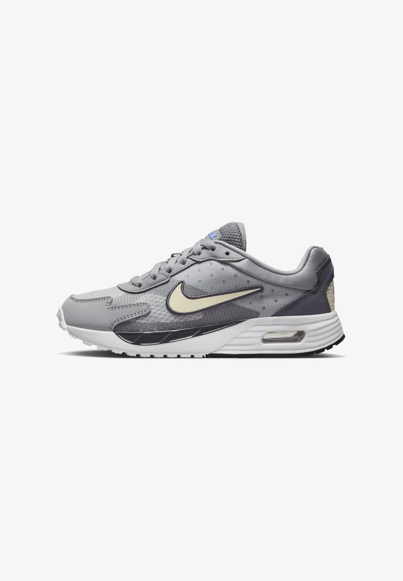 Nike Air Max sneaker szürke színben, texturált felsőrésszel, fehér középtalppal, visszafogott fekete részletekkel, és látható légpárnázással a saroknál.
