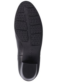 Semelle de chaussure noire avec motifs de grip segmentés, talon texturé et le nom de la marque Gabor embossé près de la voûte plantaire.
