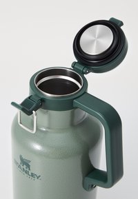 Green stainless steel water bottle with a textured finish, secure lid, large handle, and internal metallic rim, featuring a flip-top opening.