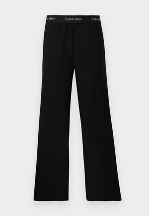 Pantalon noir à large jambe avec une texture lisse, doté d'une taille élastique portant l'inscription "Calvin Klein" en texte blanc. Design minimaliste.