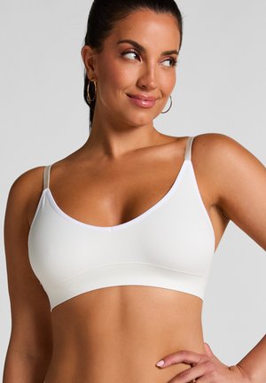 Weiße, nahtlose Bralette mit glatter Oberfläche, verstellbaren dünnen Trägern und einem breiten Unterband. Verfügt über einen tief ausgeschnittenen Ausschnitt.