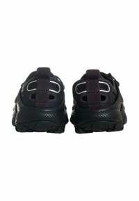 Scarpe sportive nere con parte superiore in mesh traforato, dettagli forati e suola in gomma con motivo antiscivolo. Presenti accenti riflettenti.