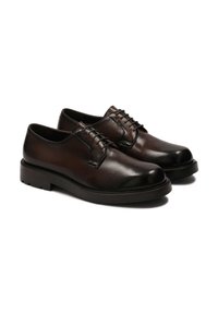 Zapatos de cuero marrón con cordones y acabado suave, punta redonda y suela de goma, con costuras claras en contraste y un diseño clásico.