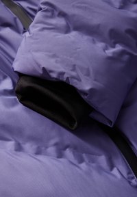 Fialová péřová bunda s texturovaným povrchem, černým vnitřním manžetou a elegantním designem s jemným leskem, která ukazuje moderní izolační vlastnosti.