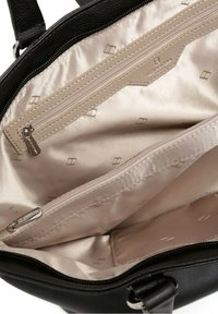 Mustan nahkakäsilaukun sisäosa, jossa on beige satiinivuori, kaksi vetoketjullista osastoa ja hienovarainen timanttikuvio koko sisällä.