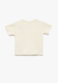 Kremowy t-shirt z krótkim rękawem wykonany z teksturowanej tkaniny, z okrągłym dekoltem i luźnym krojem z prostym wykończeniem. 