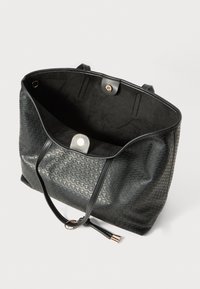 Black tote bag with embossed geometric pattern, open top with magnetic snap closure, and two thin shoulder straps with metal tips.